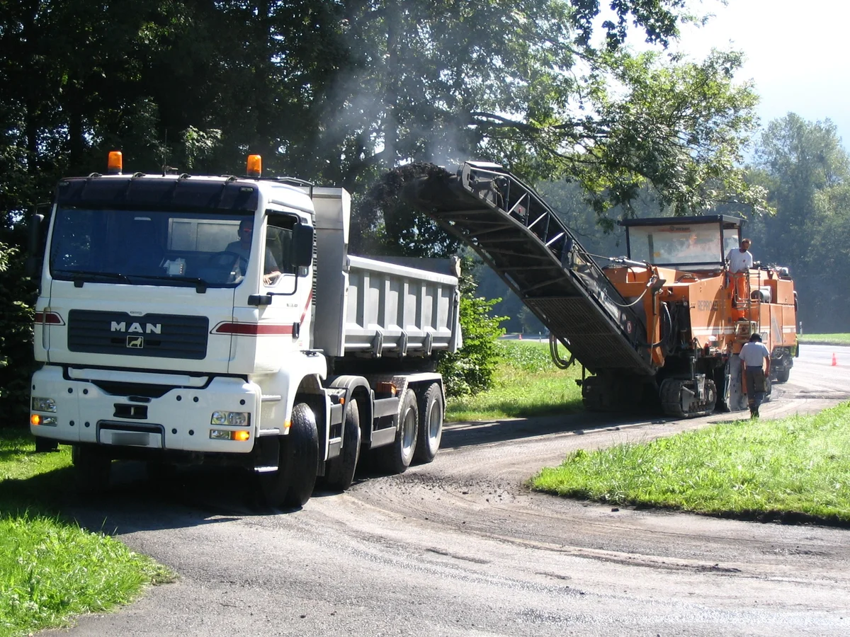 Road milling machine loading removed pavement into a truck
